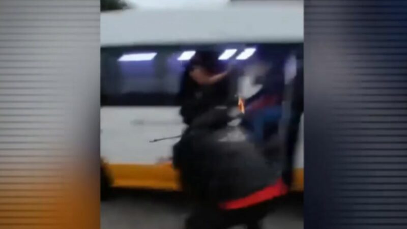 Imagen de un hombre lanzando un explosivo contra una combi