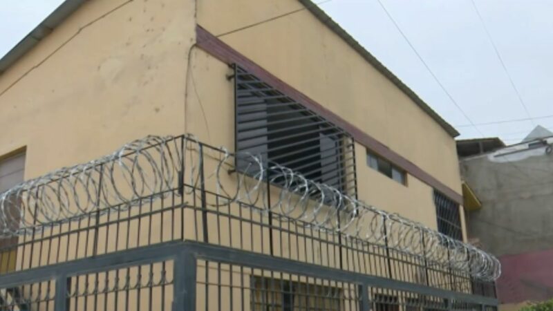 Fachada de una vivienda con rejas y alambre de púas en San Juan de Miraflores
