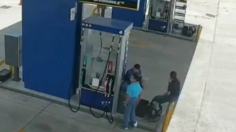 Bomberos y agentes policiales en la escena del accidente donde un auto arrolló a tres trabajadores de un grifo en Honduras