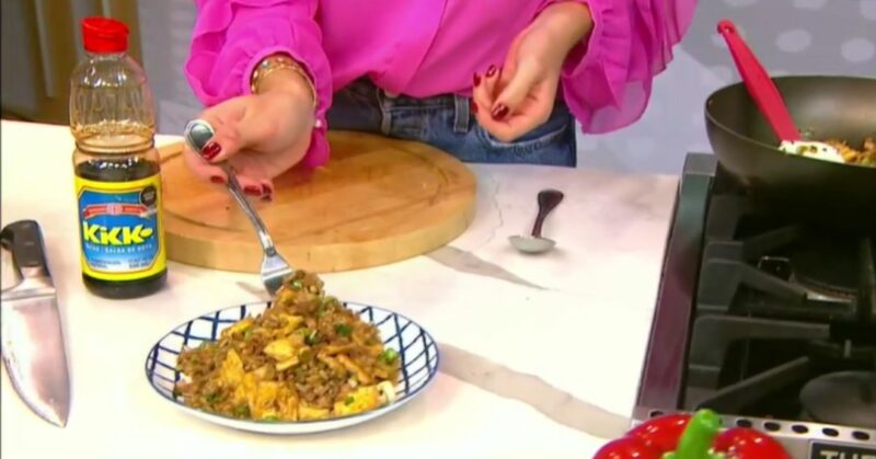 Maricucina Plevisani sirviendo arroz chaufa de quinua en el programa Así de Simple, con el wok de fondo.