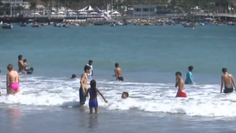 Bañistas y familias disfrutan del sol y el mar en la playa Agua Dulce de Lima en pleno invierno.